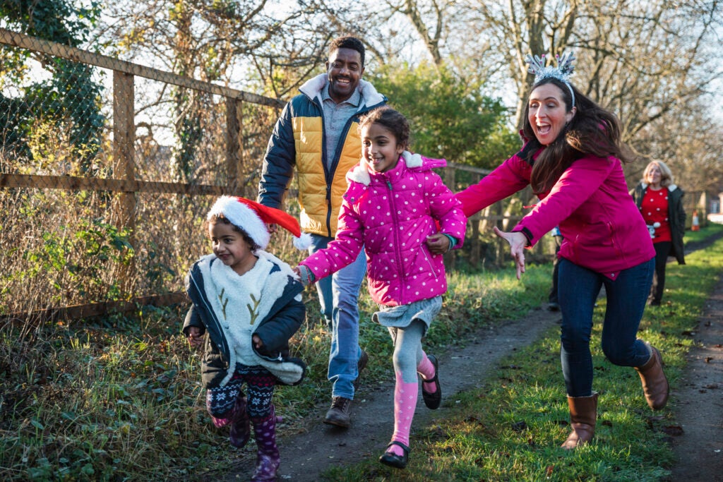 A family doing an outdoor Christmas activity to help raise money for a cause.